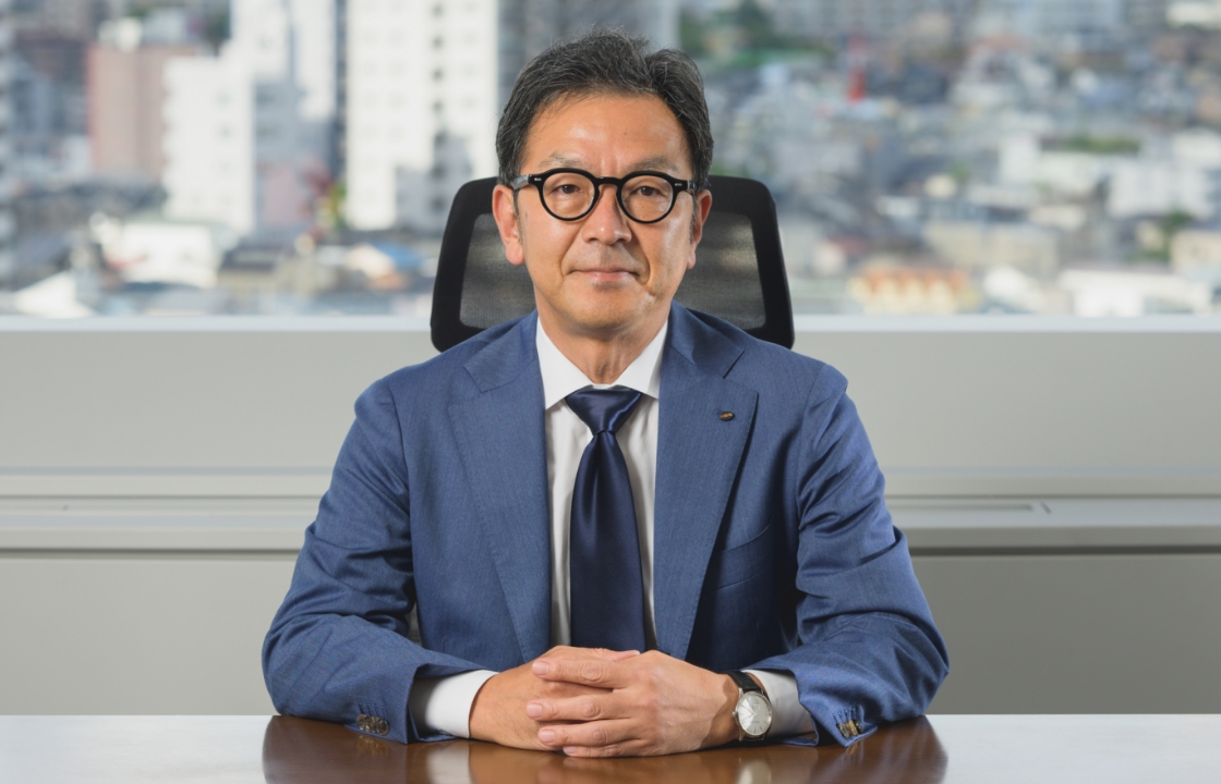 スーツを着た中年の男性がオフィスの机に座っている