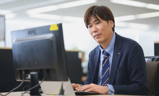 オフィスでパソコンに向かって仕事をしている男性社員