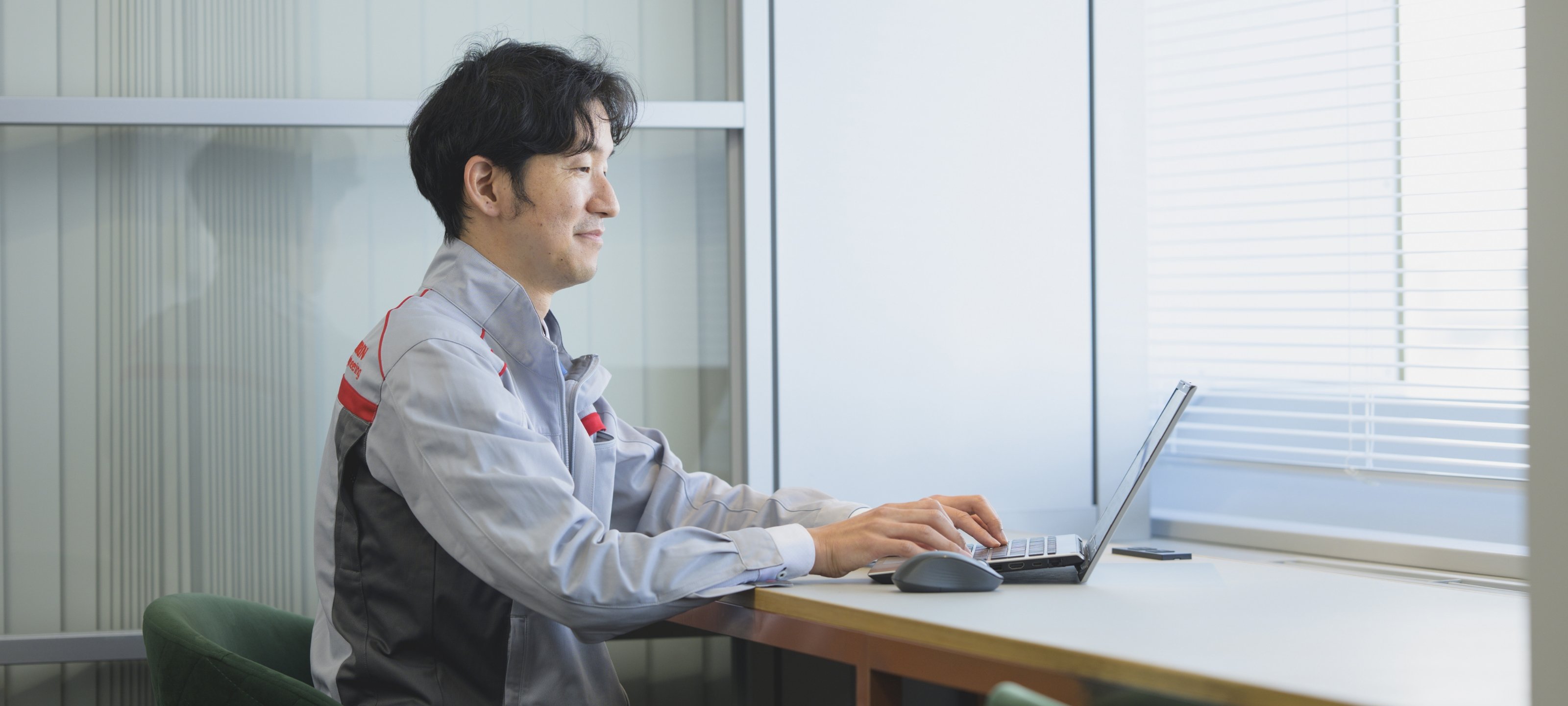 オフィスで坂本 優馬がパソコンを操作している様子