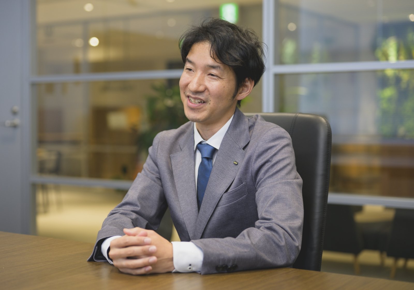 坂本 優馬が面接の場で笑顔で話している様子