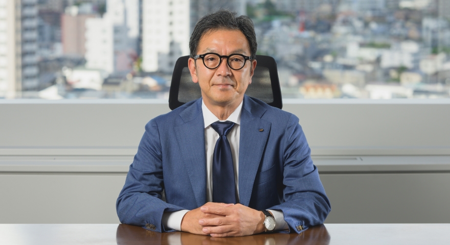 スーツを着た社長がオフィスの机に座っている