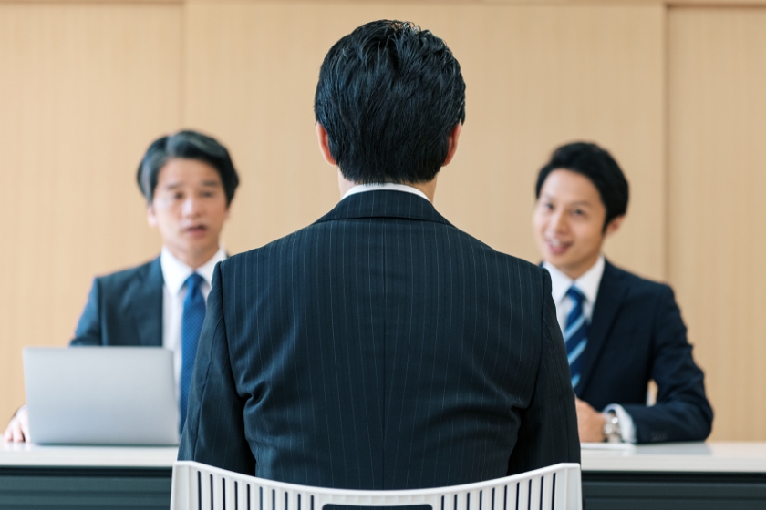 三人のアジア人男性がスーツを着てテーブルに座っている様子