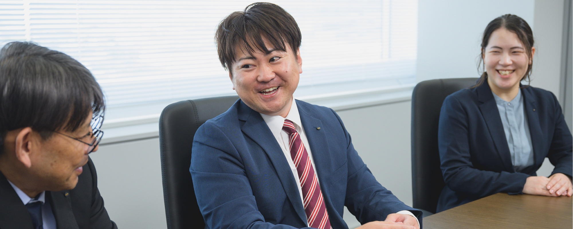 会議室で笑顔で話し合う社員たち
