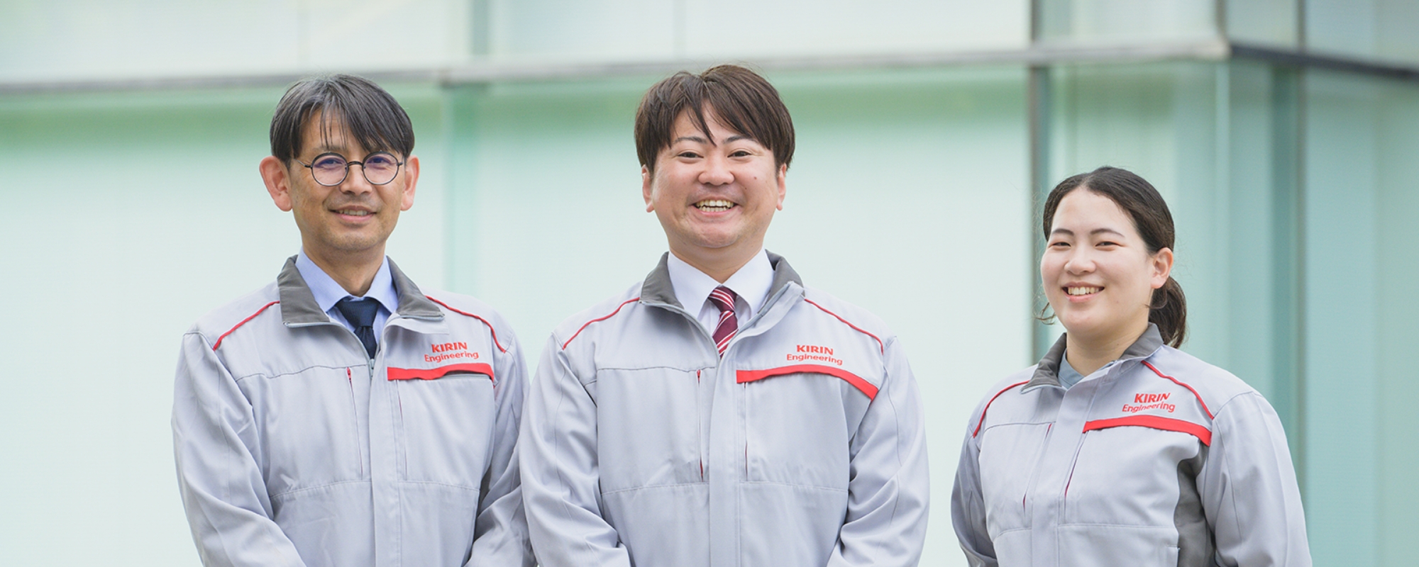 作業服を着た社員たちが笑顔で並んでいる様子