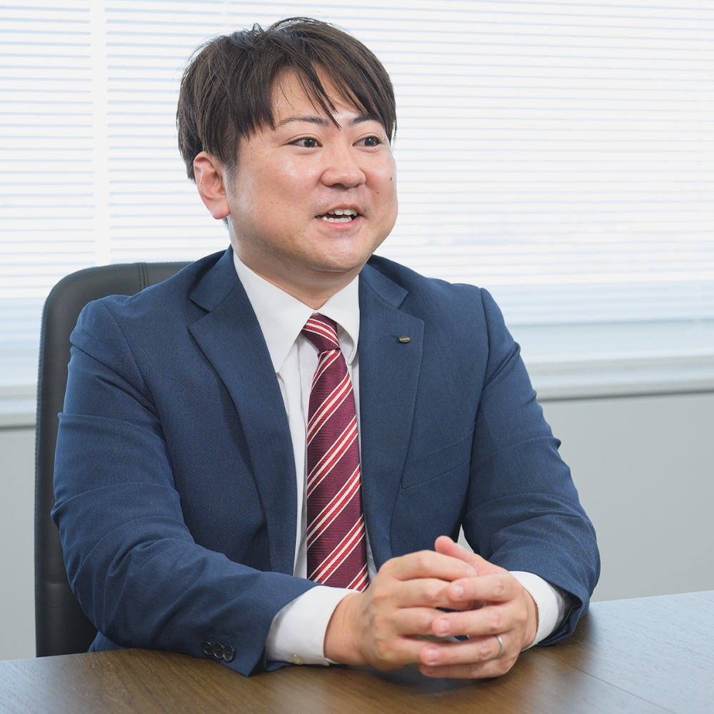 スーツを着た男性が会議室で笑顔で話している様子
