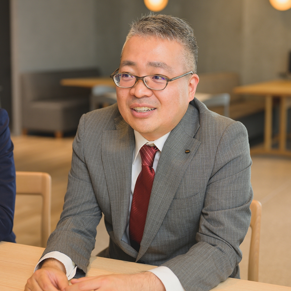 スーツ姿で笑顔を見せる男性社員のポートレート
