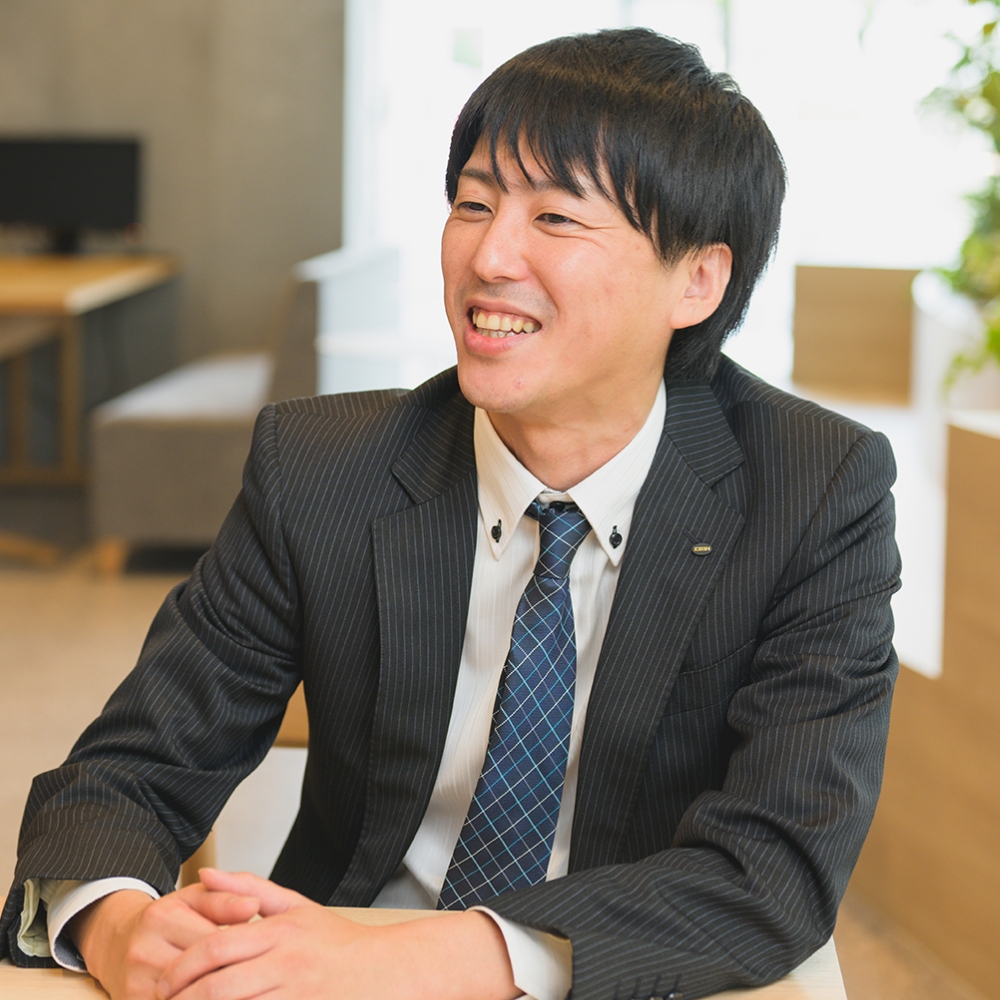 スーツ姿で笑顔を見せる若手社員のポートレート