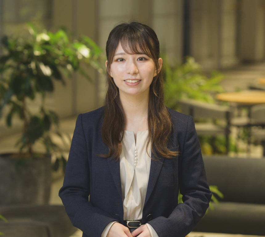 スーツを着てカメラに向かって笑顔で見つめる藤澤由佳