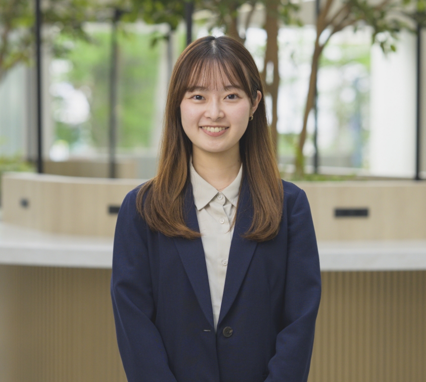 スーツを着てカメラに向かって笑顔で見つめる市村春奈