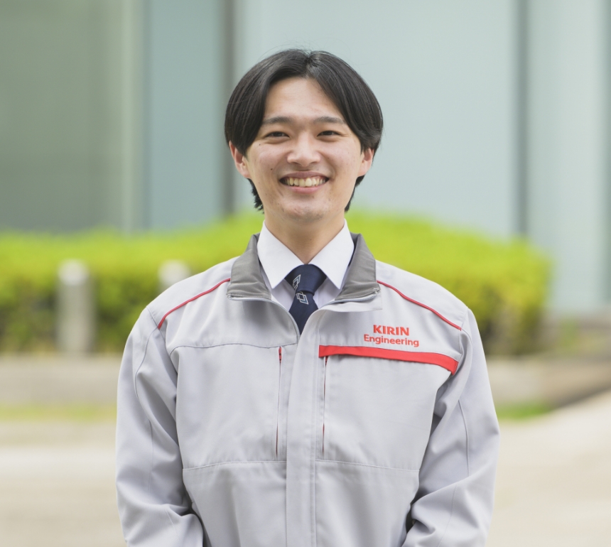 作業着を着て笑顔で見つめる櫻井敬太