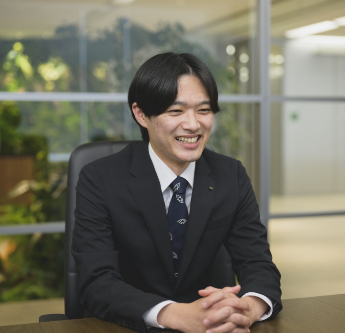スーツ姿の櫻井 敬太がオフィスでインタビューを受けている様子