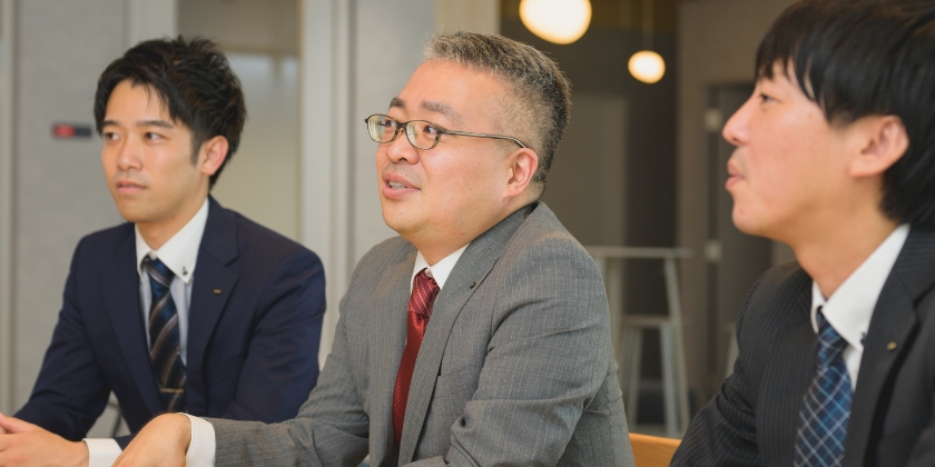 話す男性社員3名